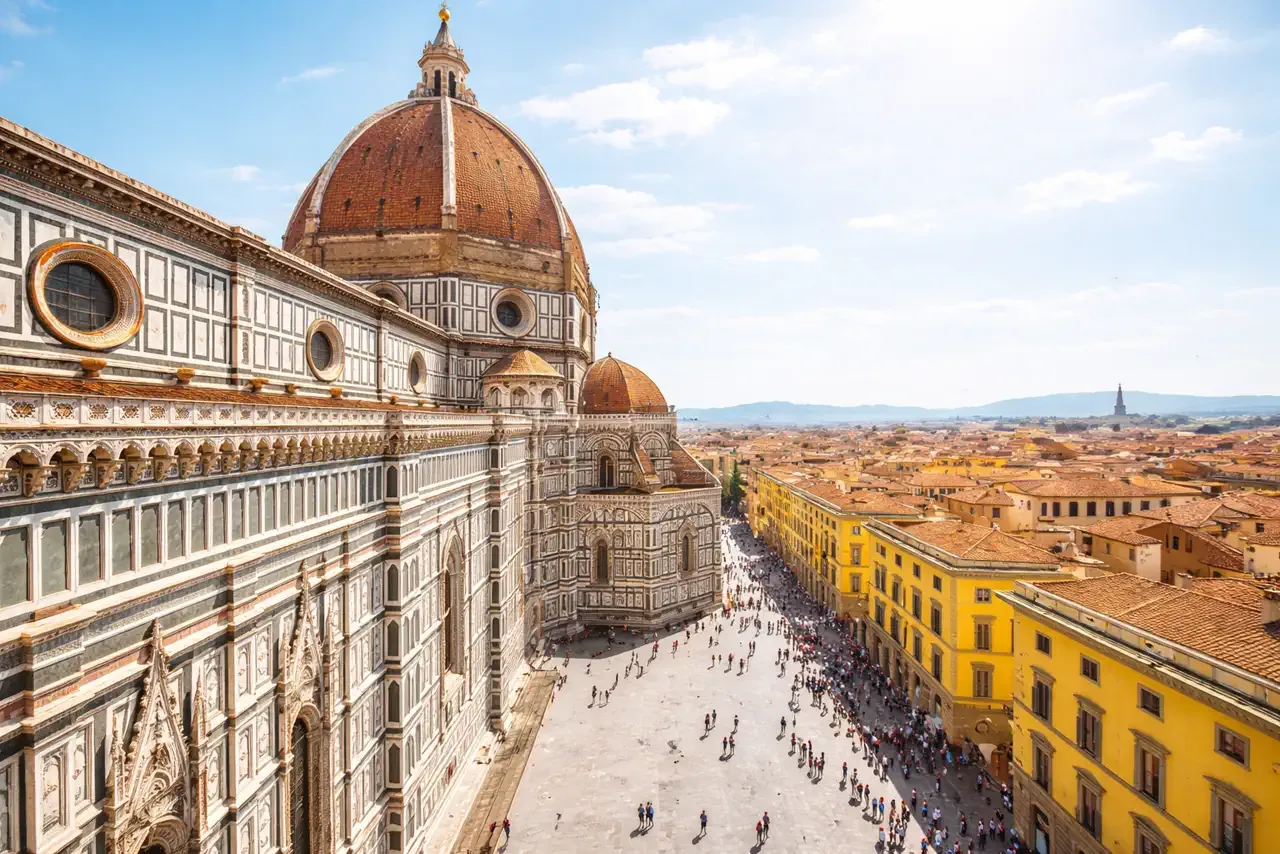 Brunelleschi's dome and the marble flank of Florence Cathedral seen from Giotto's Bell Tower, with Piazza del Duomo and the city rooftops below