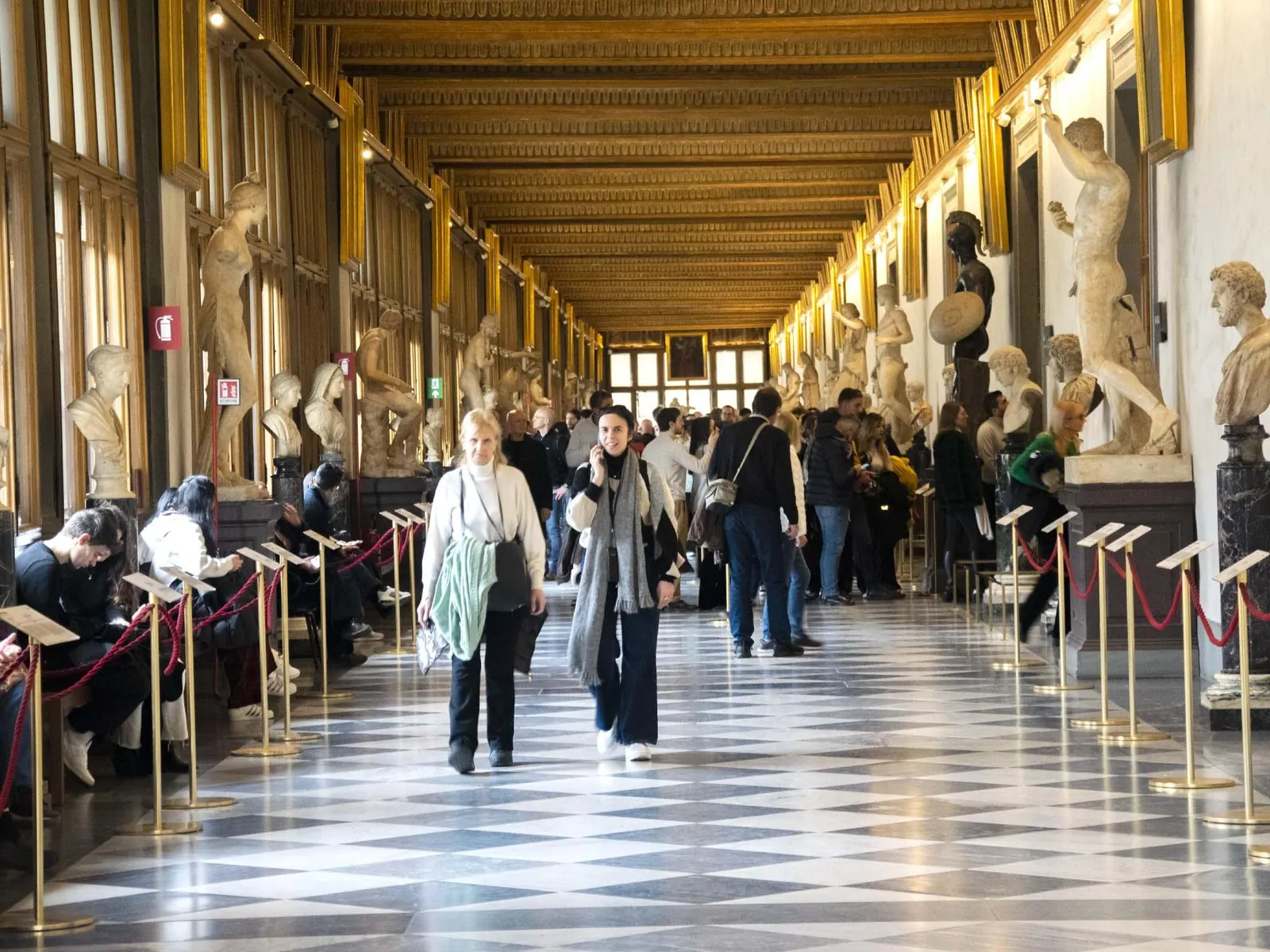 Visitors walking the Uffizi's west corridor