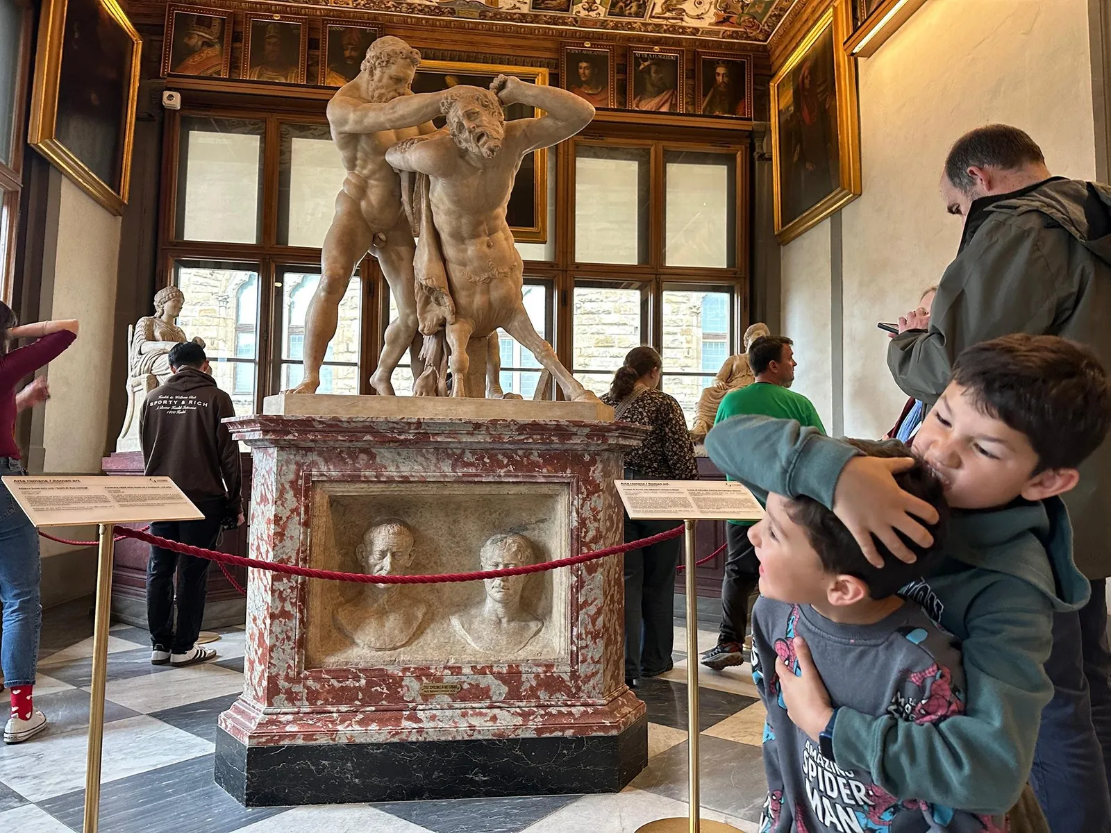 Kids studying the Roman Wrestlers sculpture in the Uffizi