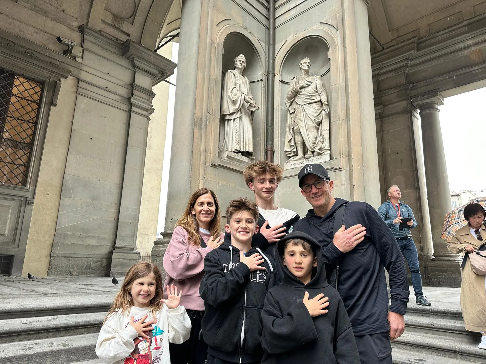 A family with four children under the statues of the Uffizi loggia