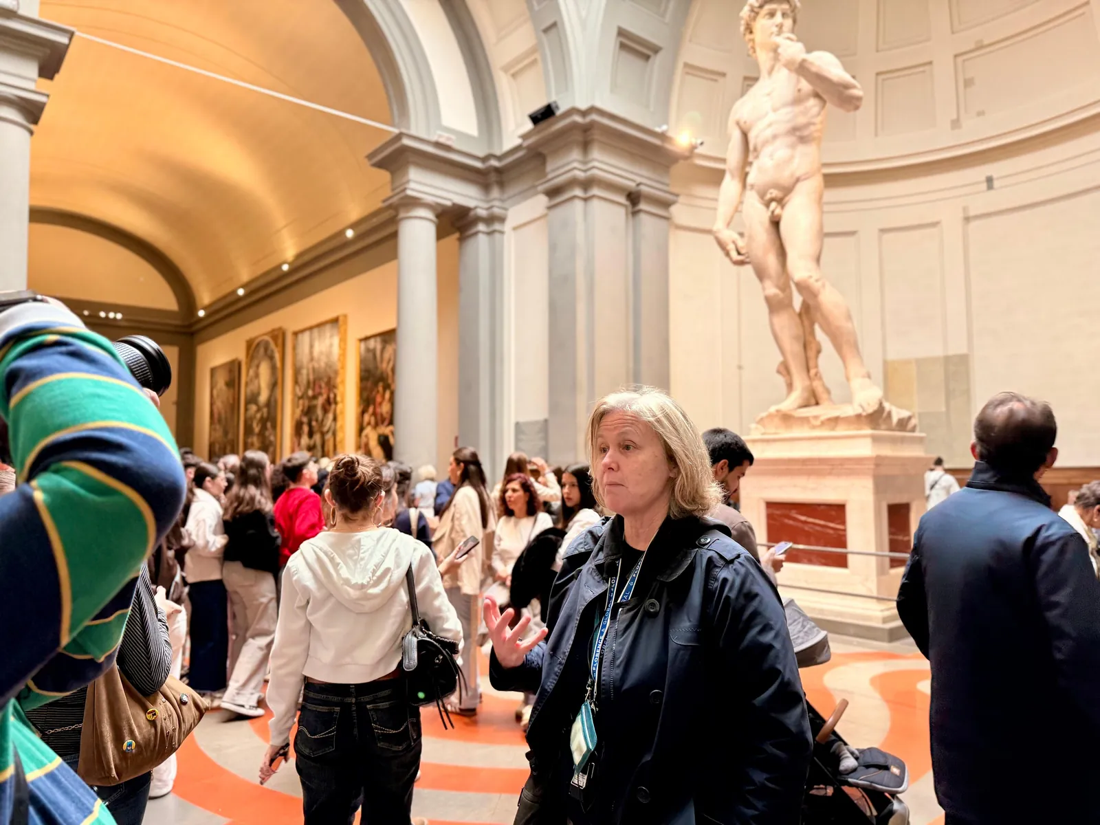 Guide talking to a small group beneath Michelangelo's David in the Accademia