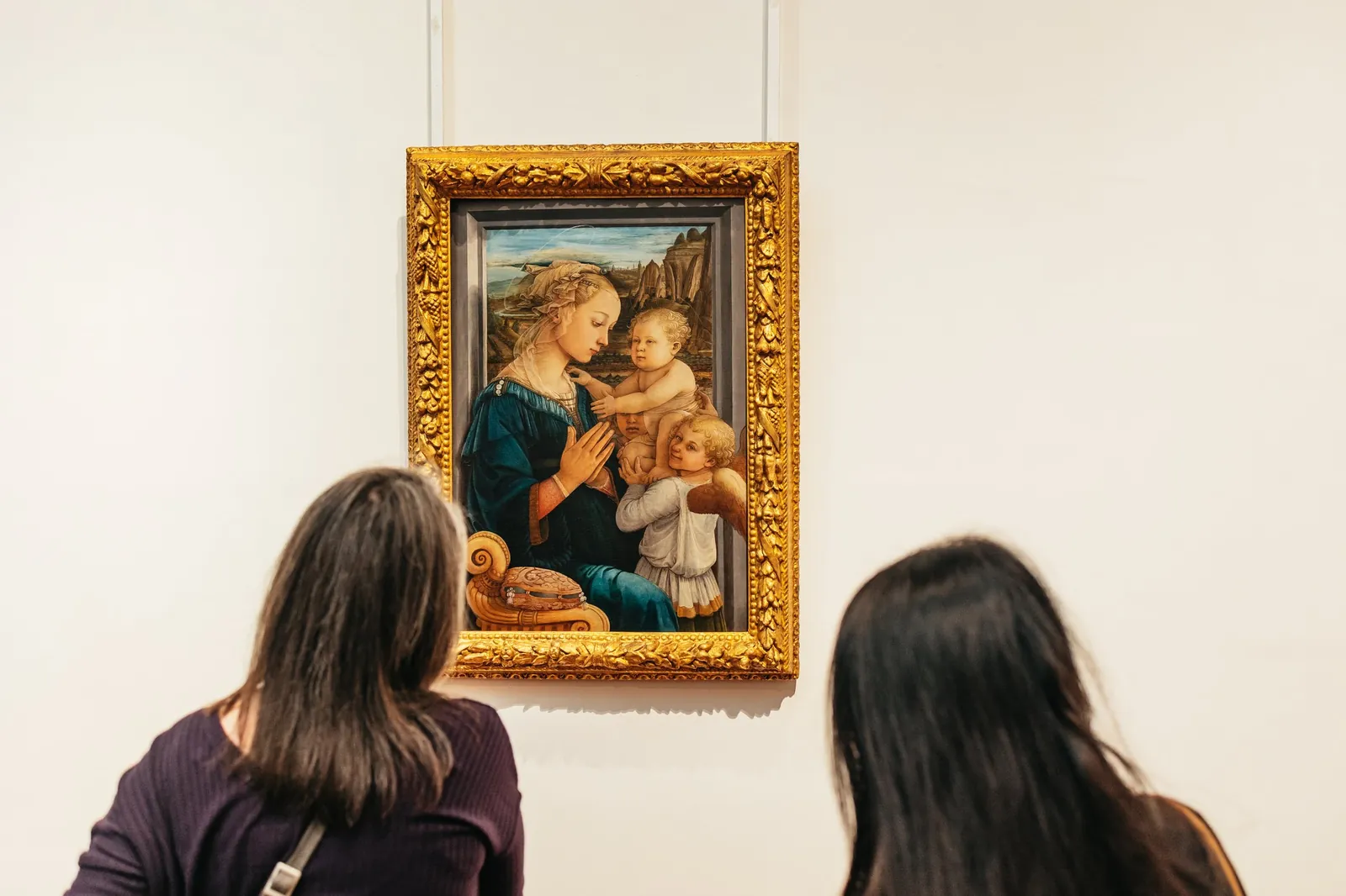 Visitors looking at Filippo Lippi's Madonna and Child with Two Angels