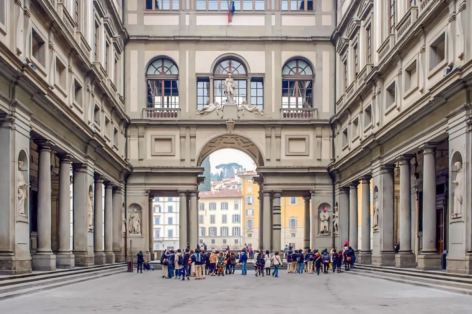 Tour groups gathering in the Uffizi courtyard by the Arno arch
