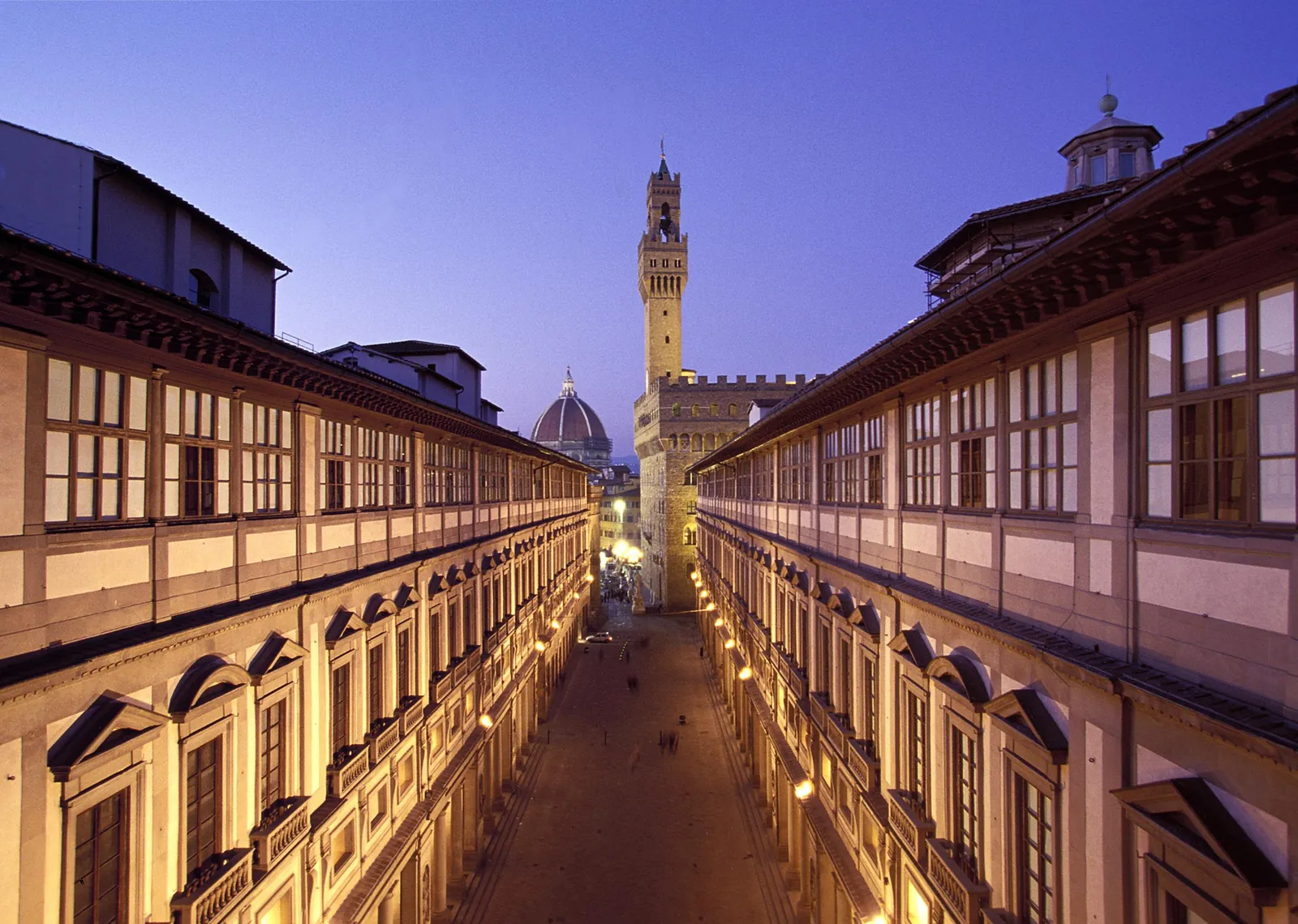 Uffizi Gallery courtyard at dusk with the tower of Palazzo Vecchio beyond
