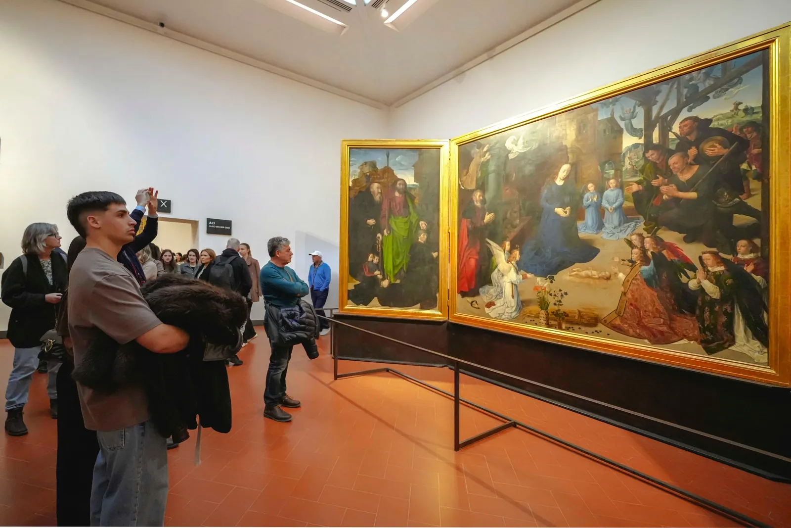 Visitors in front of Hugo van der Goes's Portinari Altarpiece