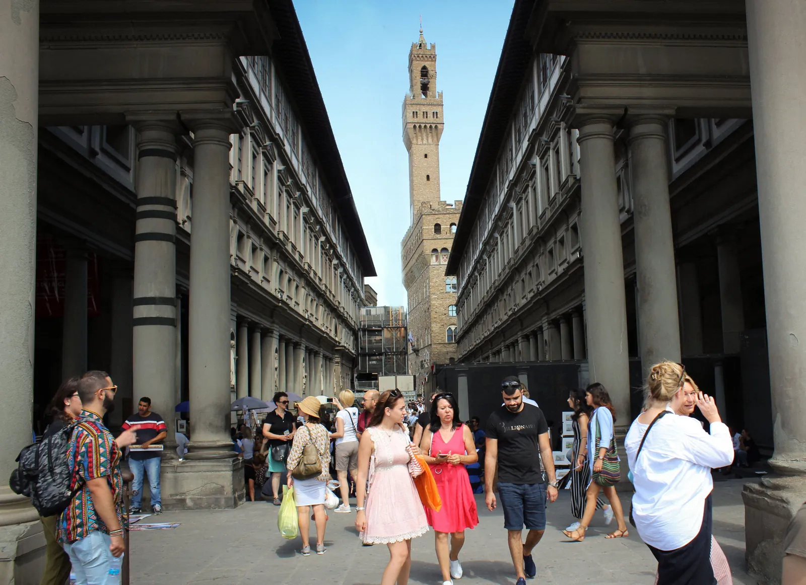 Visitors walking through the Uffizi courtyard toward Palazzo Vecchio