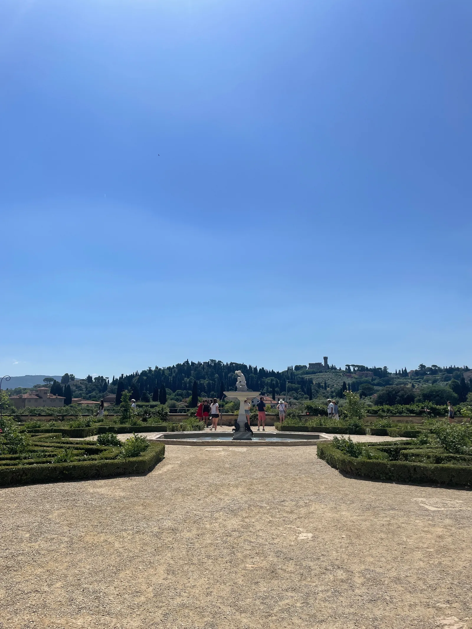 A lawn and hedges in the Boboli Gardens with the hills beyond