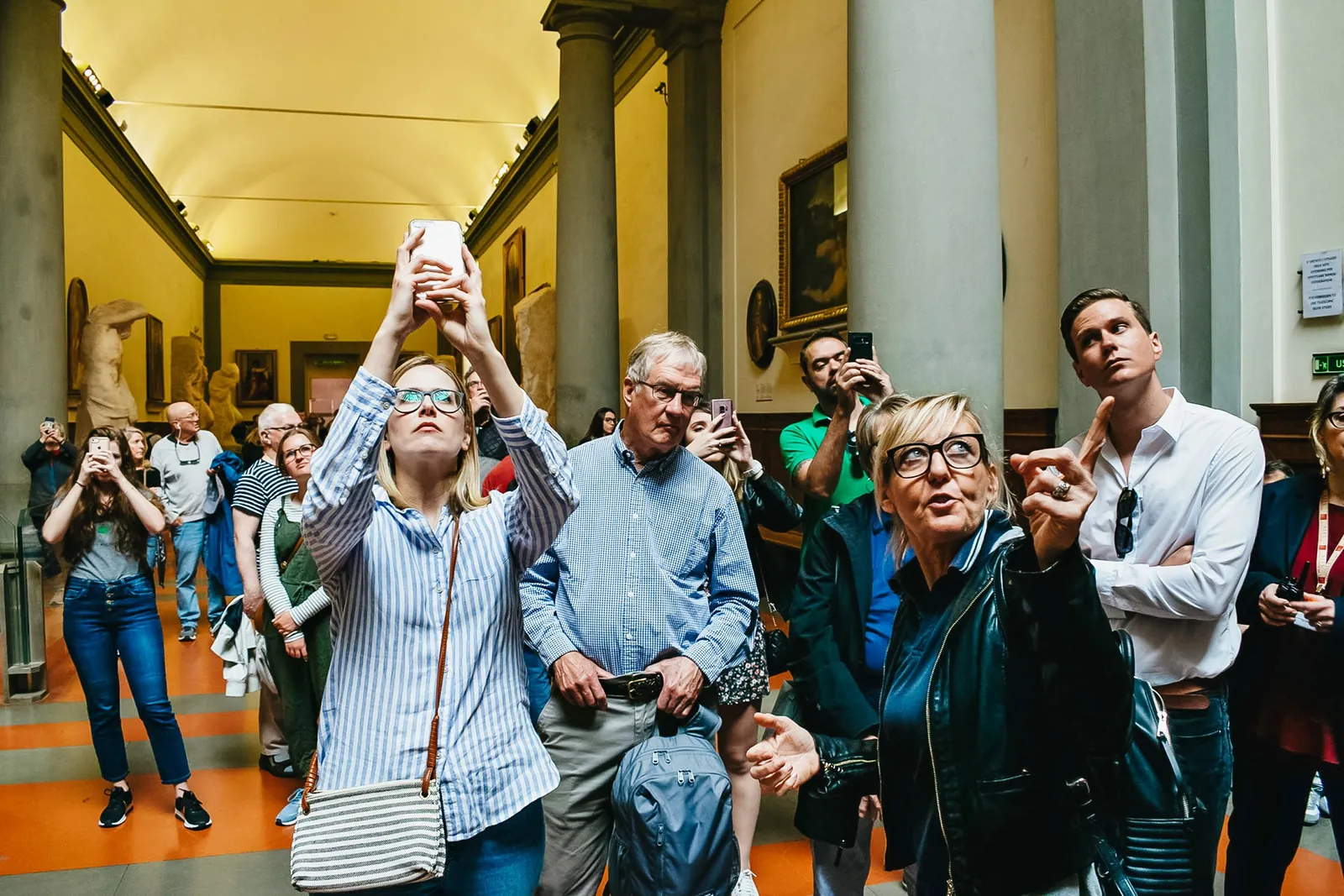 Visitors looking up at and photographing Michelangelo's David