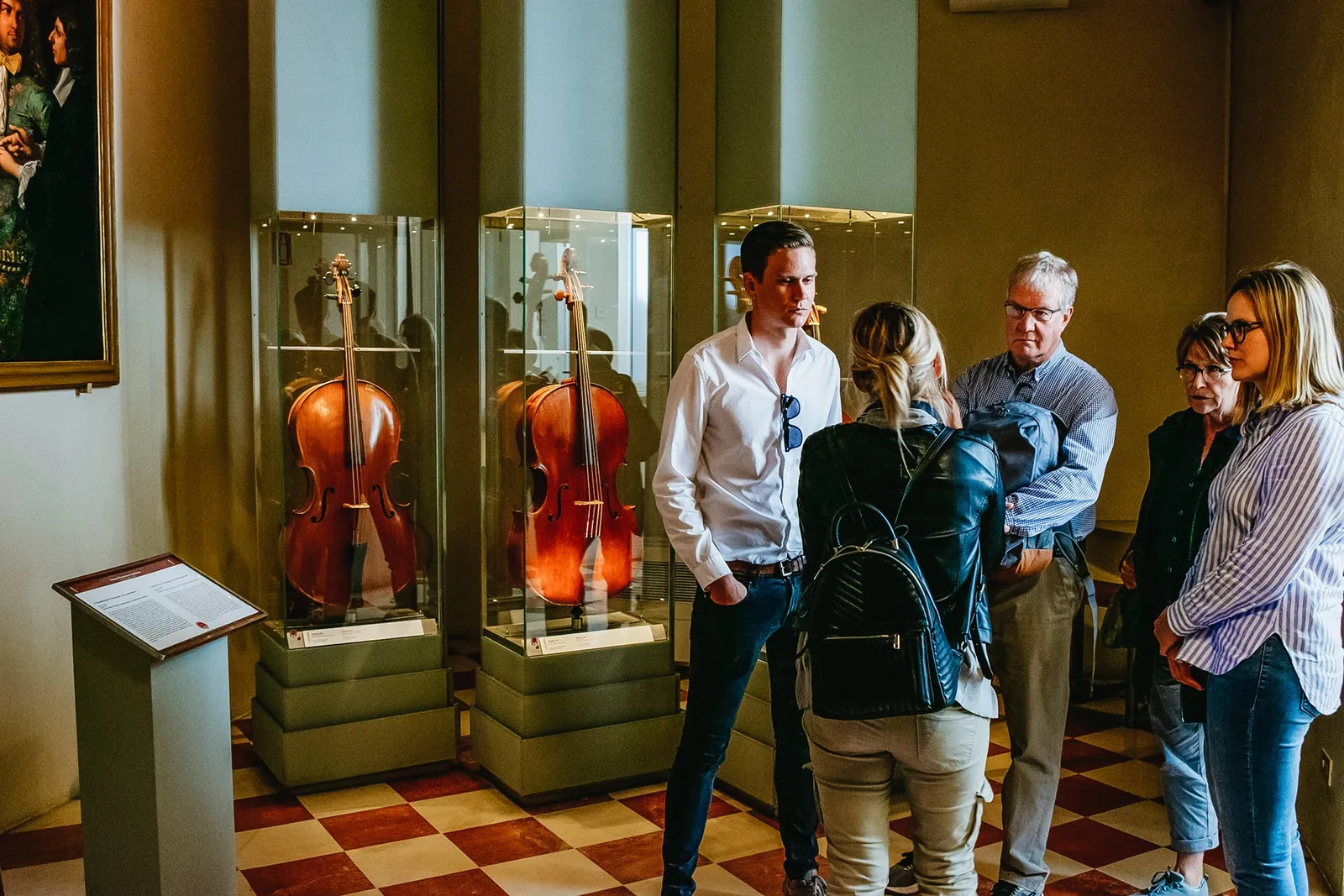 Visitors beside the Medici string instruments in the Accademia's music collection