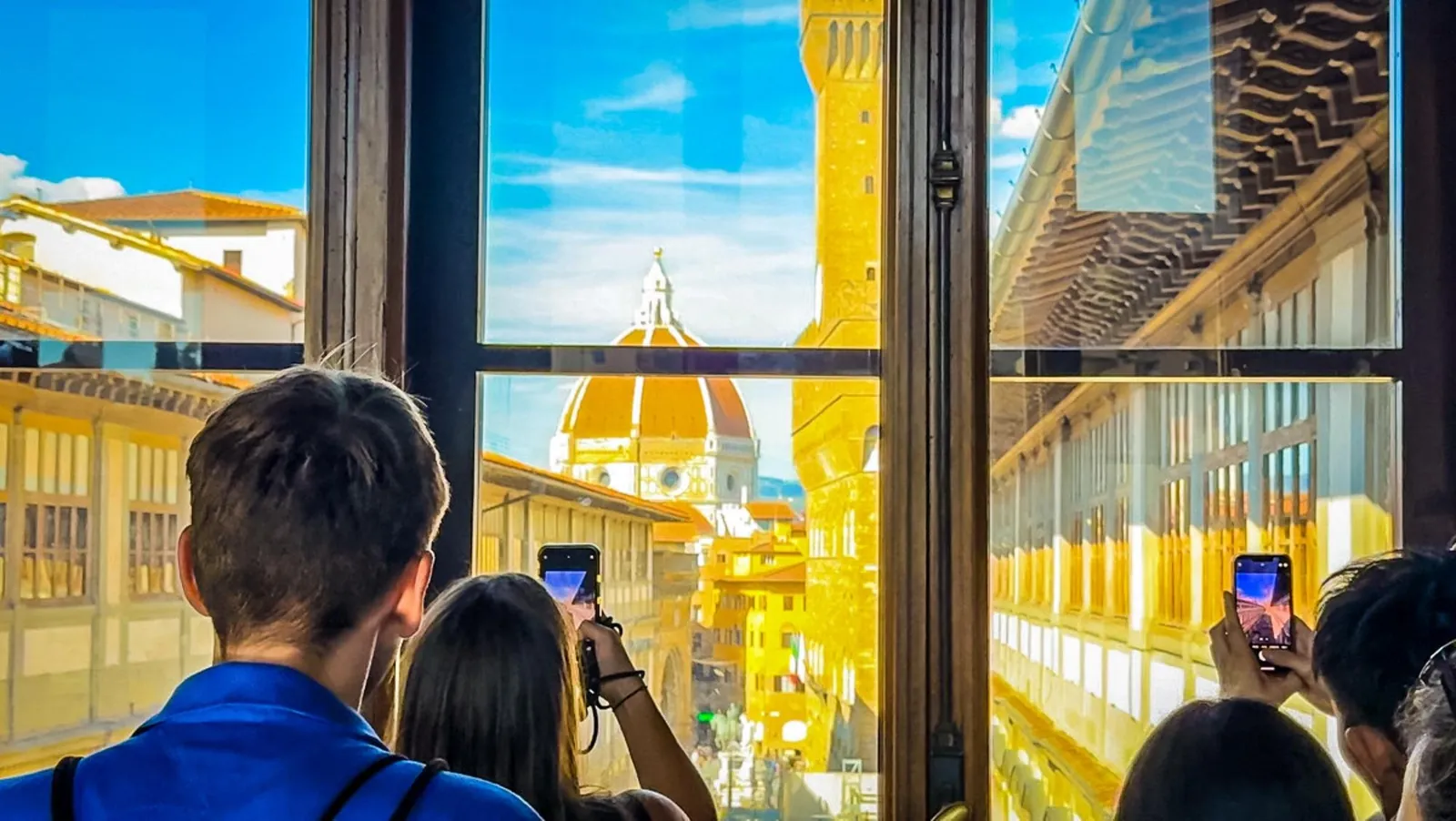 Visitors photographing the Duomo and Palazzo Vecchio from the Uffizi's upper windows