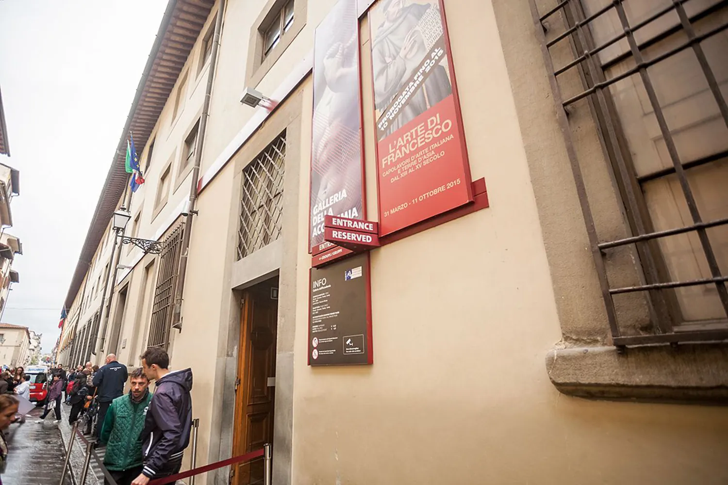 The reserved-entrance door of the Accademia Gallery on Via Ricasoli, with the queue alongside