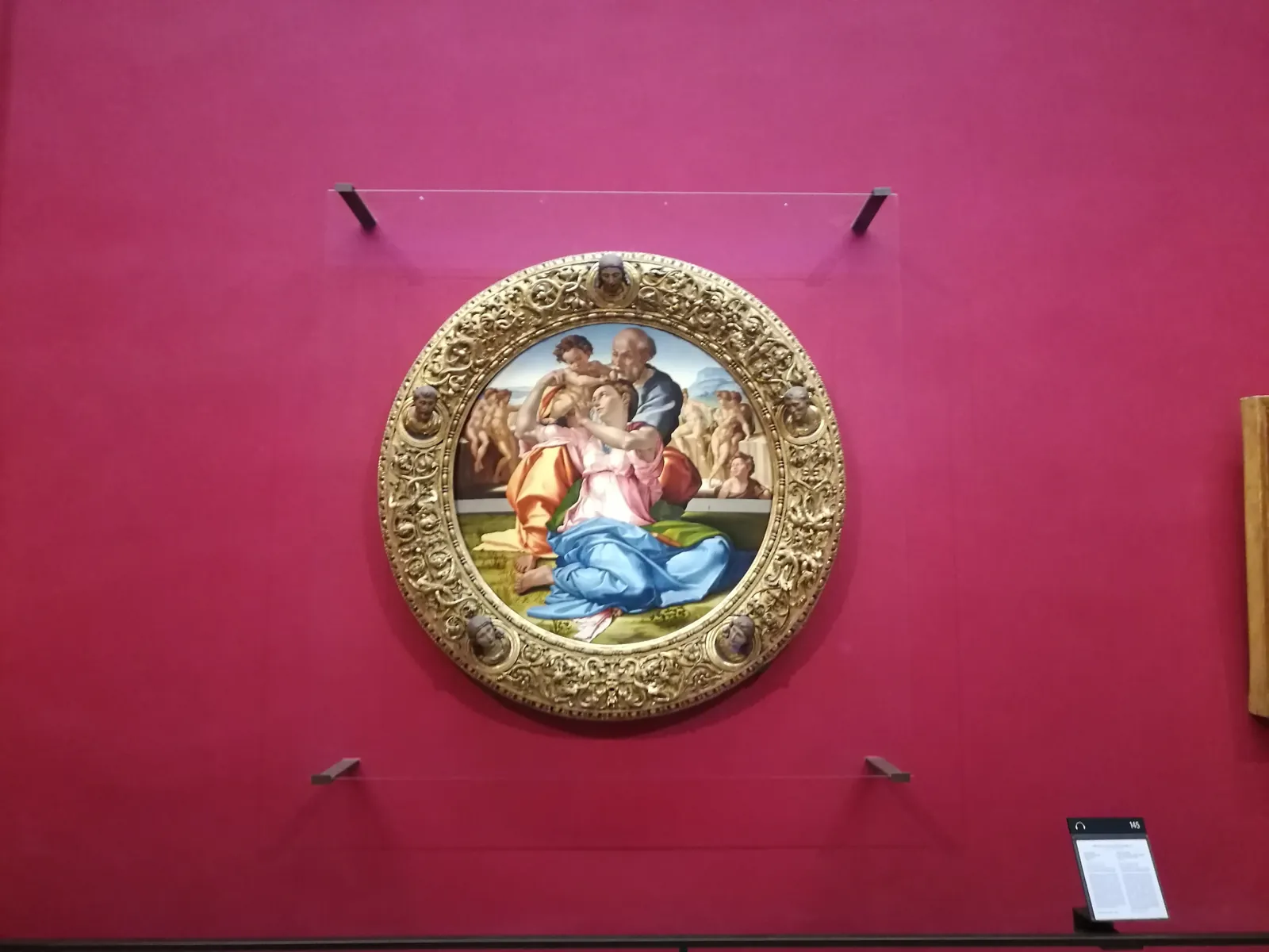 Michelangelo's Doni Tondo on its red wall