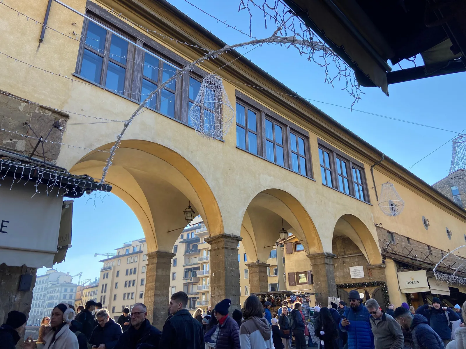 The Vasari Corridor's arches above the crowds at Ponte Vecchio