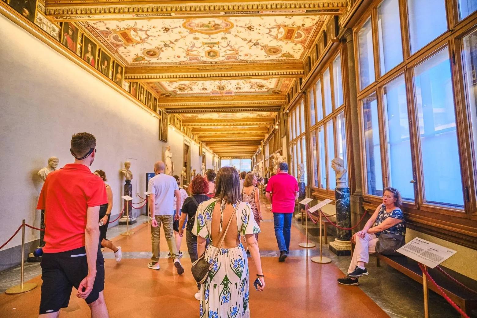 Visitors walking the Uffizi corridor toward the river end